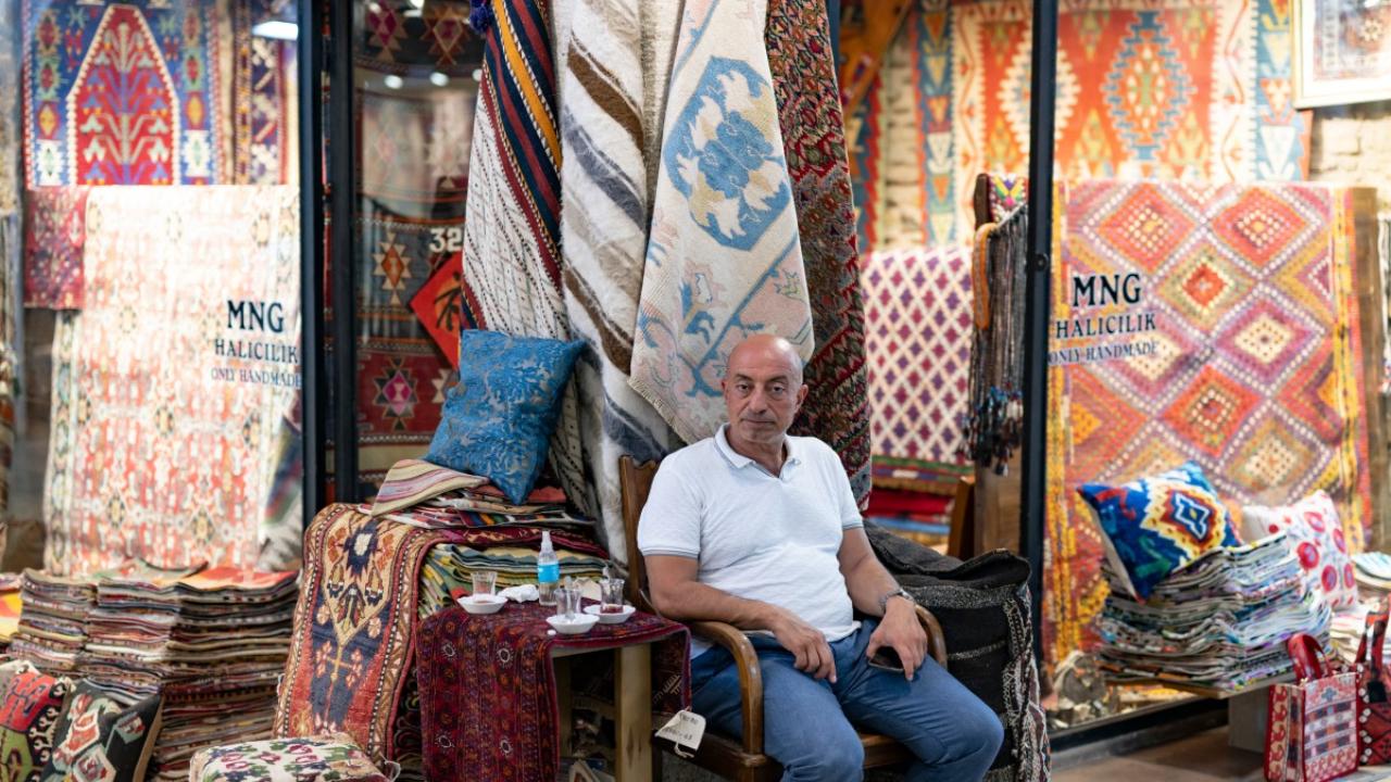 Hasim Gureli poses at his carpet shop in Grand Bazaar
Where heritage Turkish crafts once flourished under the Ottoman-era marketplace's painted ceilings, the elegant carpet store run by Hasim Gureli is now surrounded by shops selling designer dupes.
