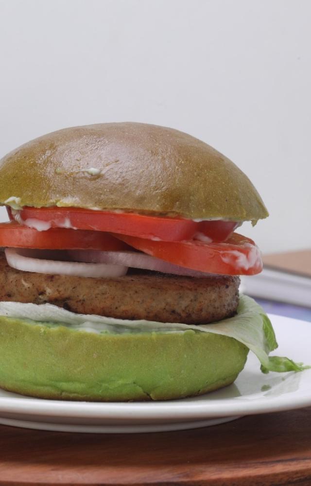 This delicious creation features a plant protein-packed patty nestled in a vibrant spinach bun