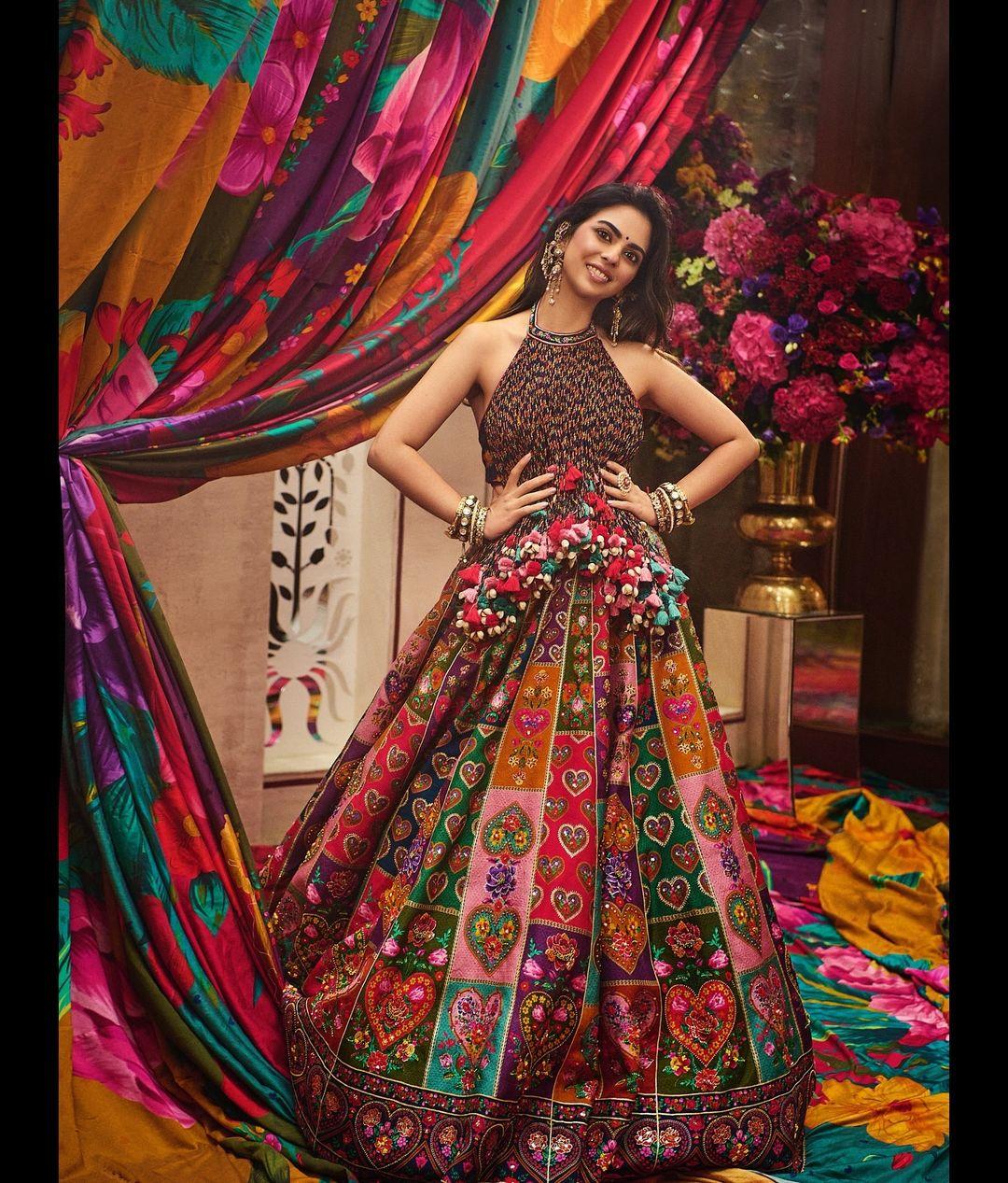 Celebrity stylist Anaita Shroff Adjania styled Isha Ambani in a personalized lehenga set from Torani for the Haldi ceremony. Anaita posted Isha's photos on Instagram, where she looks stunning in a sleeveless blouse adorned with tassel embroidery, a halter neckline, colorful tassel decorations, a backless design, and a flattering silhouette.