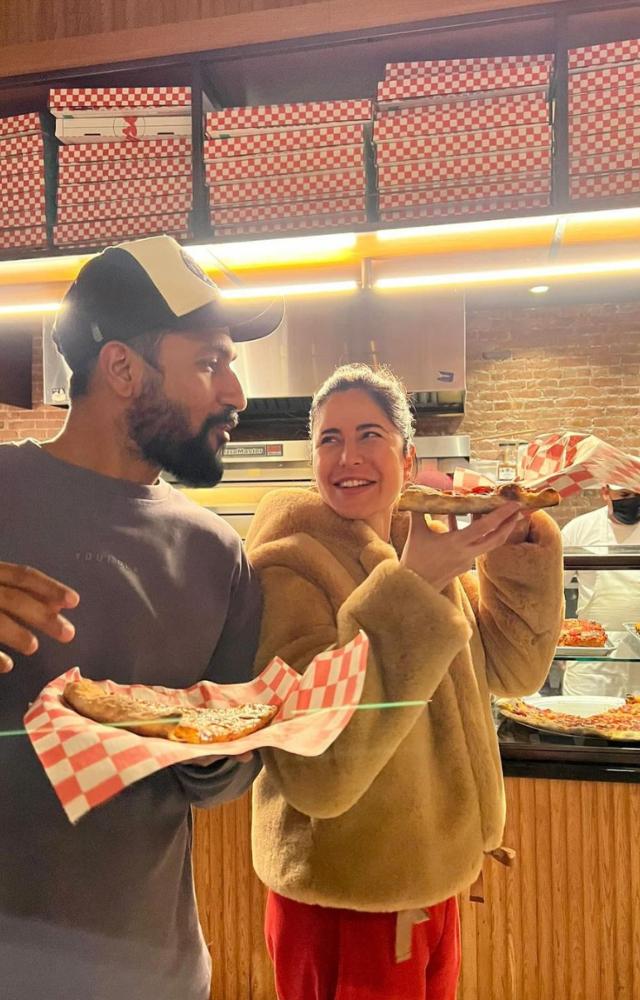 A picture shows the couple all smiles as they gorge on their cheat meal - a hearty slice of pizza. 
