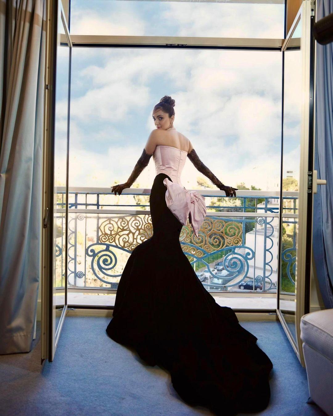 Her dreamy outfit included delicate satin fabric, a corset detail, an off-the-shoulder neckline, a figure-hugging fit, a black velvet fishtail hemline, and an extended train at the back.