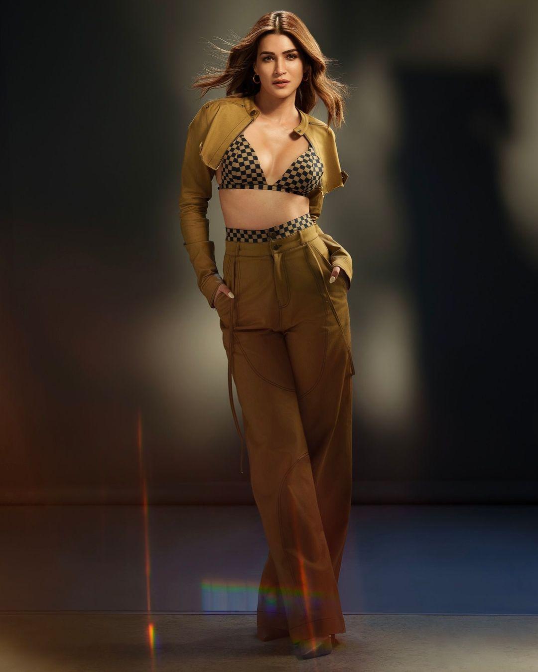 She paired it with a blue and camel plaid bralette featuring a deep V-neckline, thin shoulder straps, and a tie back. Kriti completed her chic look with matching high-waisted straight-leg trousers.