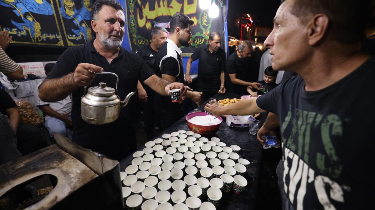 In Photo: A volunteer distributes tea while Shiite Muslims take part in mourning rituals during Ashura on Al-Kifah Street in central Baghdad on July 16, 2024