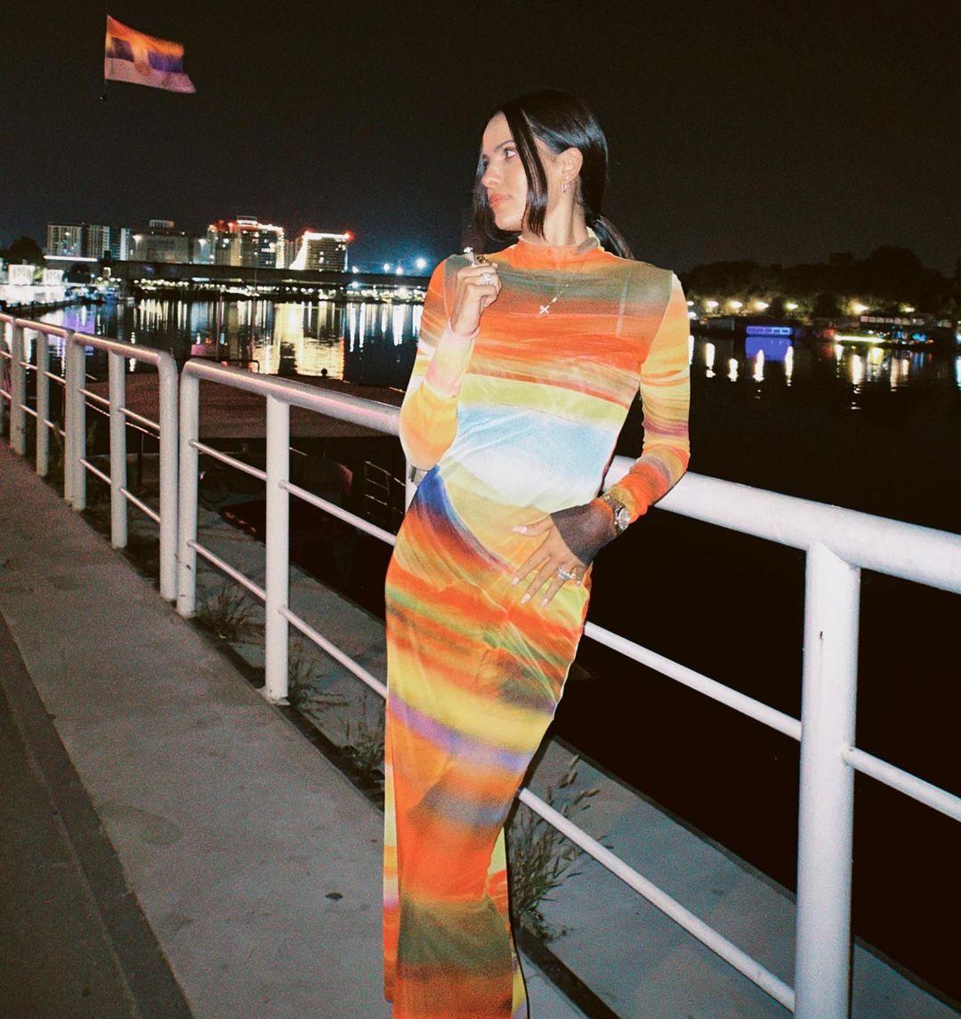 Natasa wowed in a striking orange abstract midi dress that hugged her figure perfectly.