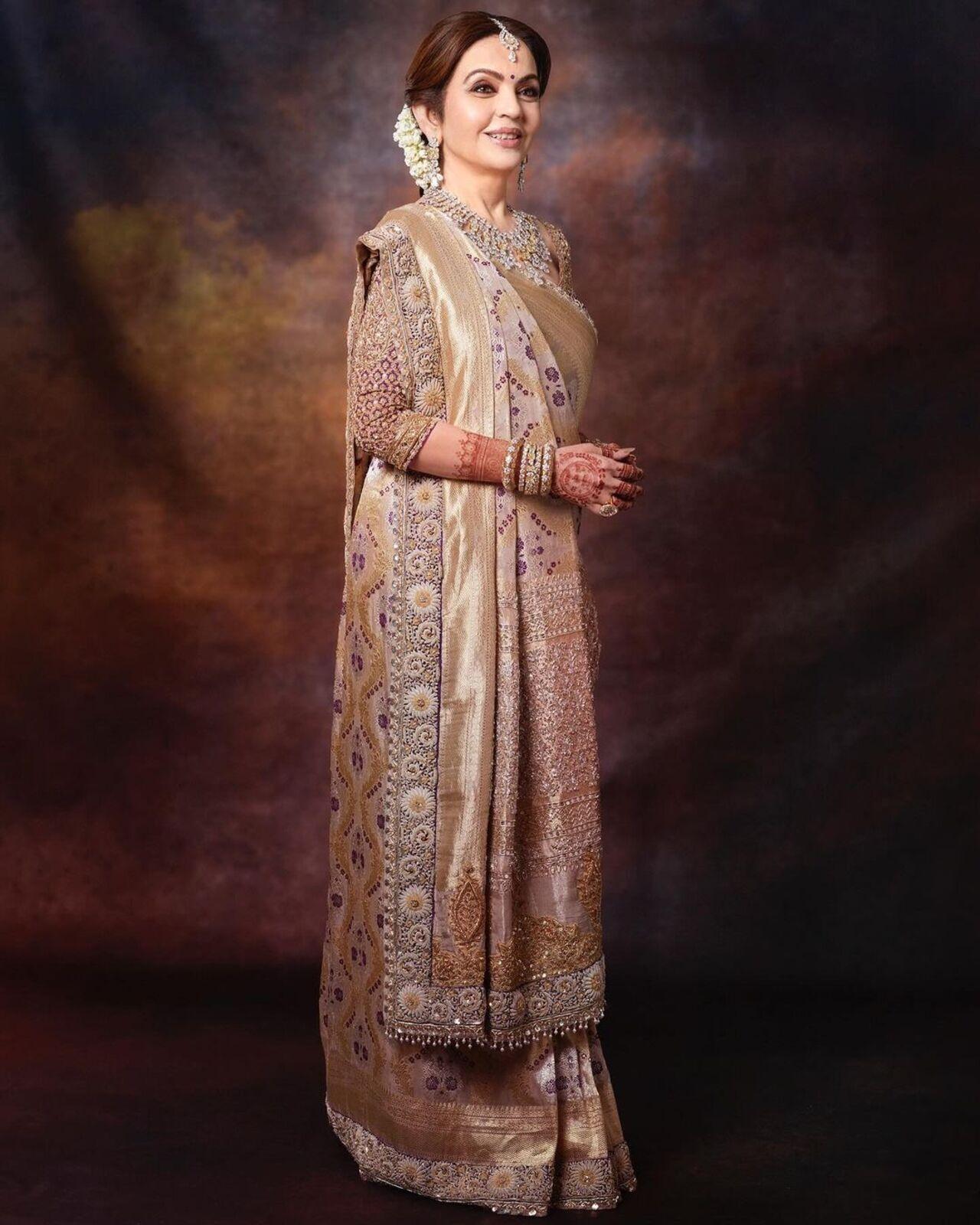 Nita wore a tissue Banarasi saree draped in traditional Gujarati style for another reception. The saree was hand-crafted and took 70 days to complete by two skilled weavers. It was designed by Manish Malhotra. 