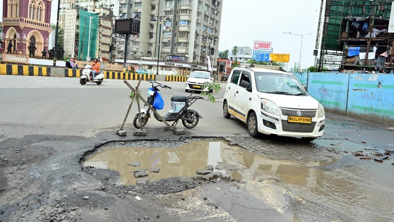 A make-shift barrier was placed near the water-filled potholes to avoid vehicles from driving into it