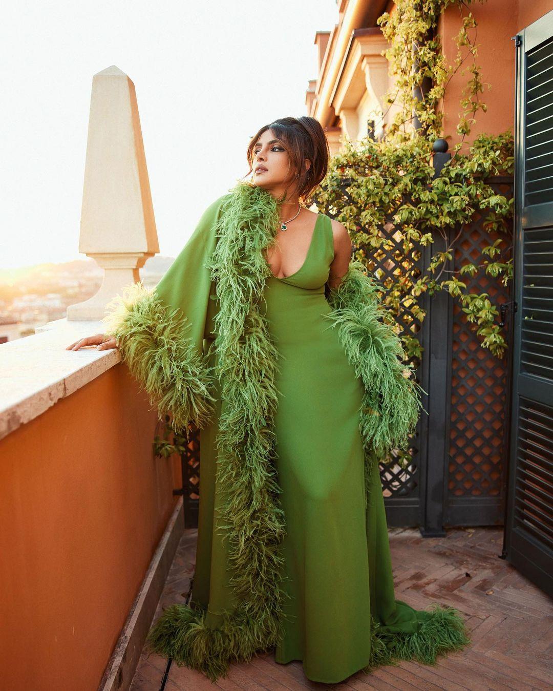 She complemented the outfit with a set of emerald and diamond jewelry, including a ring, necklace, and earrings, and carried a sparkling Valentino purse with the brand's 