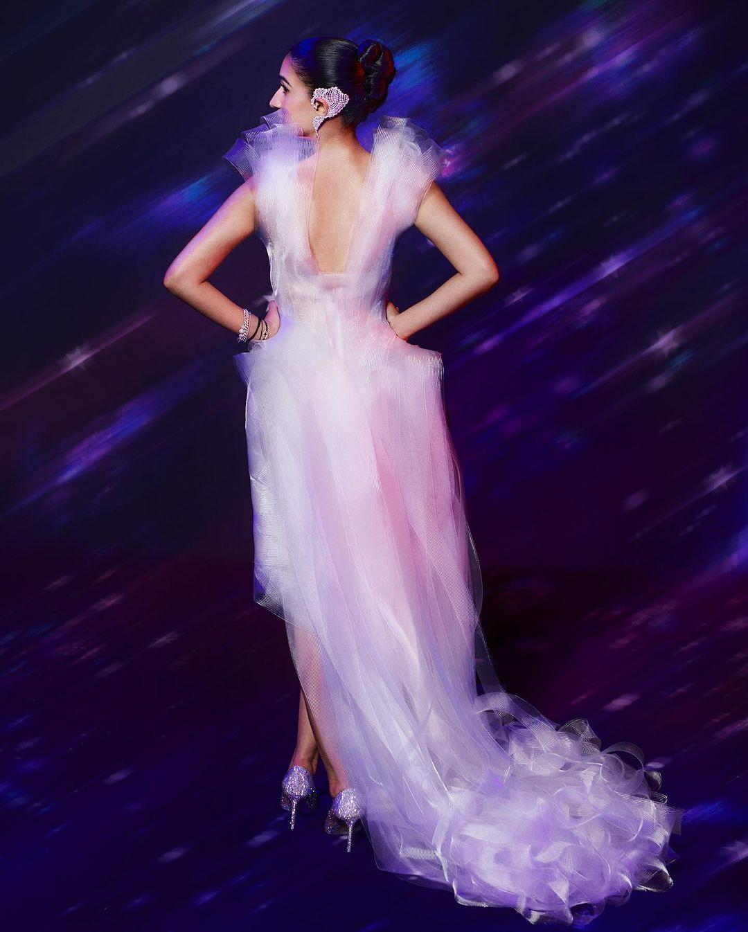 The lavender gown included a long, floor-sweeping train with strands and structured sleeves. Radhika kept her jewelry minimal, wearing an earring and ear cuffs on her left ear along with several silver and diamond rings.