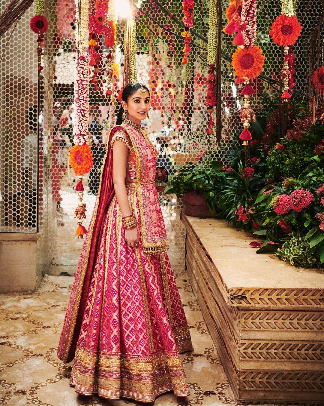 Radhika Merchant’s orange and rani pink lehenga for her mausalu is filled with sentimental details. It is made from Bandhani textile, a craft from her hometown of Gujarat. The red Gharchola Bandhani is often worn by Gujarati brides-to-be as a symbol of their new married status.
