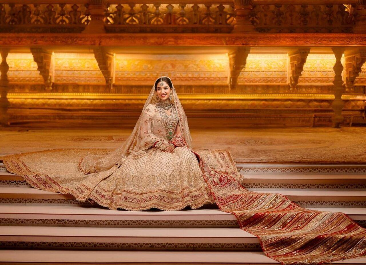 The head veil has impossibly delicate jaali work while the detachable trail is a Zardozi marvel of 80 inches.