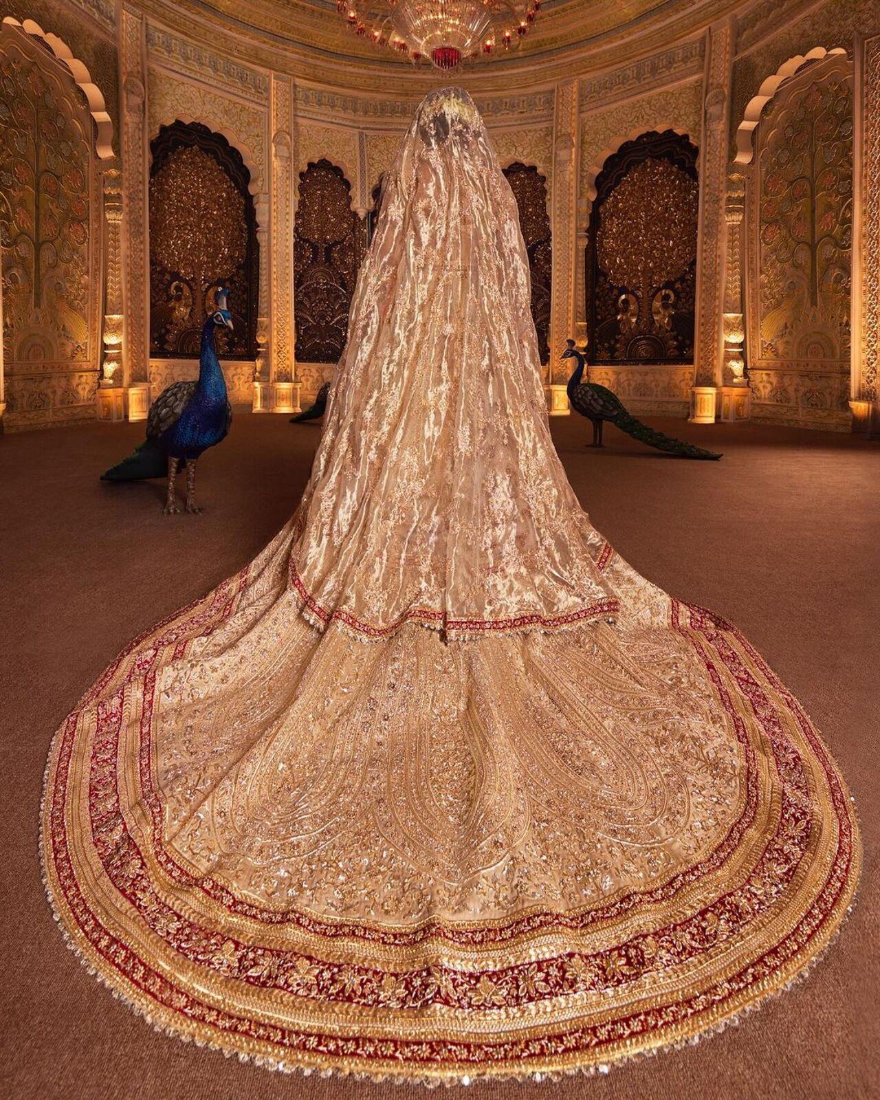 The ivory Zardozi cut-work ghagra is an innovative ensemble that merges traditional patterns with details of western silhouettes. Consisting of a trailing ghagra layered with a second detachable trail, a 5meter head veil and a tissue shoulder dupatta, the outfit was created by 25 of the most gifted kaarigars at Abu Jani Sandeep Khosla.