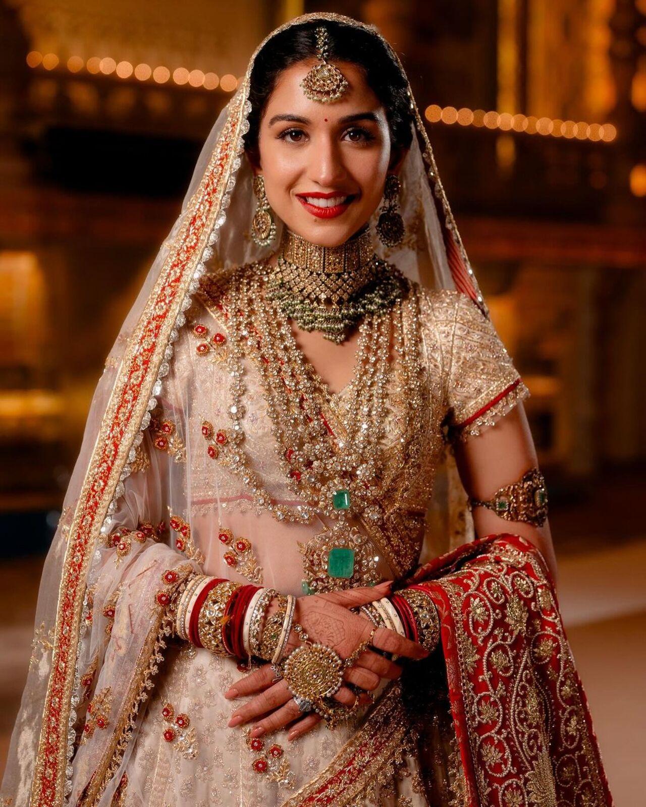 The ghagra sparkles with three borders of red, which is also the colour of lasting love. Its workmanship is the finest amalgamation of Naqshi, Saadi and Zardozi symmetrically hand-embroidered in intricate floral booties that are lavishly decorated with stones, sequins, tamba tikkis and a touch of red Resham