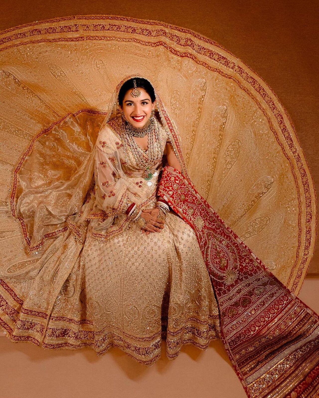 Her bridal ensemble is Abu Sandeep's exquisite interpretation of 'Panetar' - The Gujarati tradition of brides wearing red and white on their big day, styled most thoughtfully by Rhea Kapoor