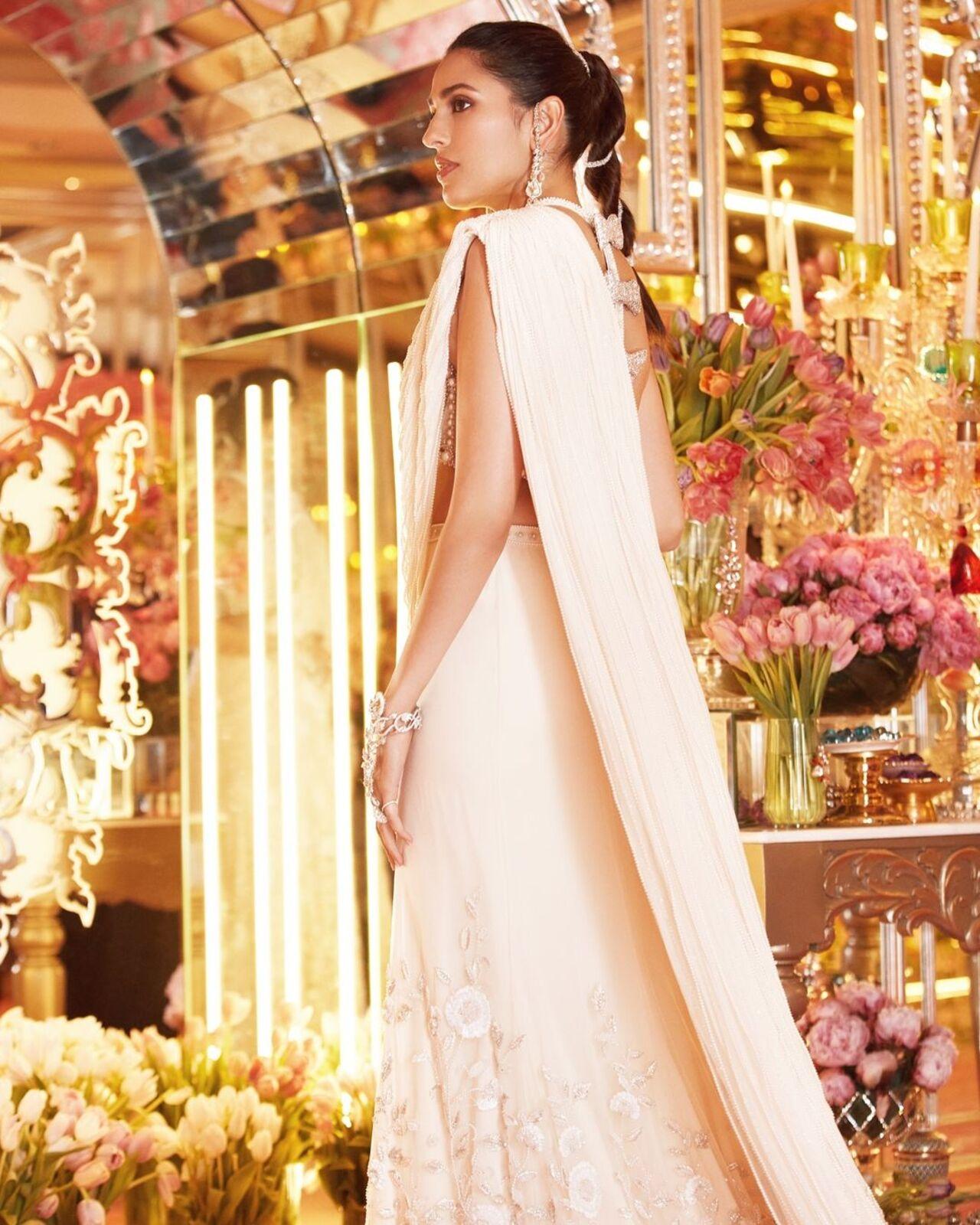 For the sangeet ceremony, Shloka was a vision in white as she donned a custom Tamara Ralph saree.