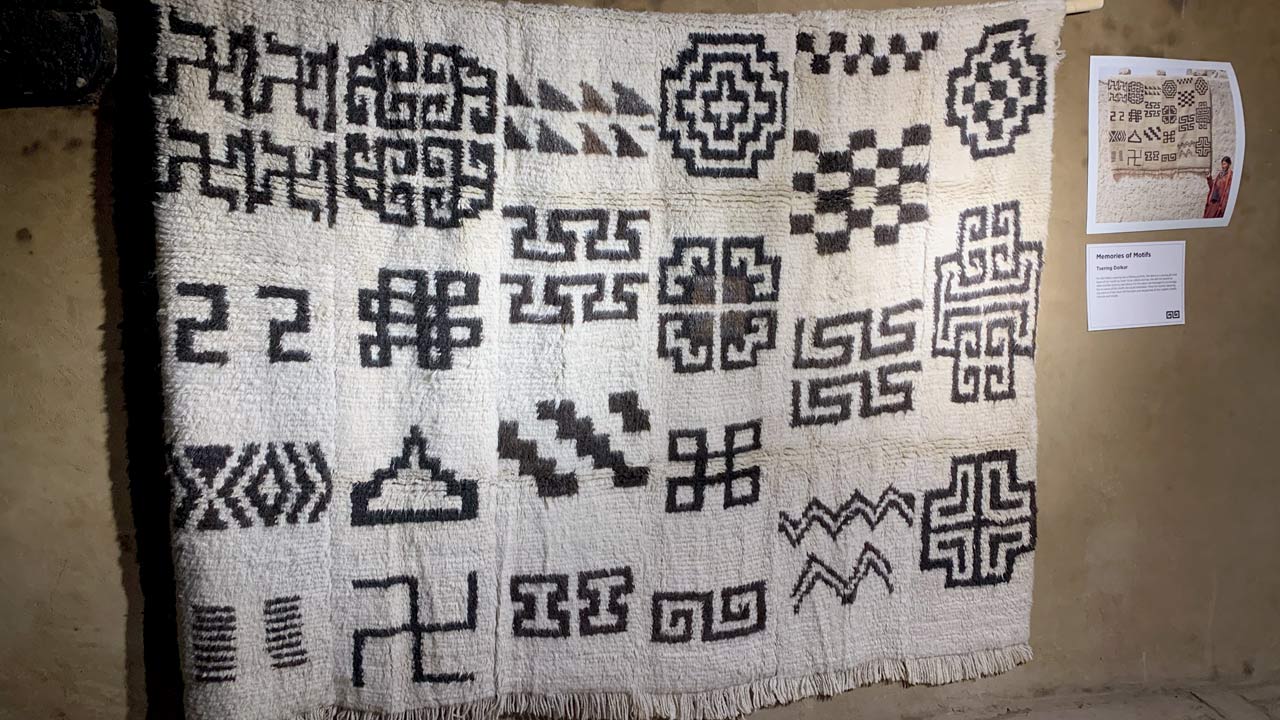 Memories of Motifs by Tsering Dolkar is part of Threads That Talk: Woven Narratives from Changthang. Abi (granny) Dolkar, a lifelong weaver, mastered Ladakhi motifs in her youth. Later, despite fading memory, she resumed weaving for this piece, intricately recreating those motifs as if she had never left the loom