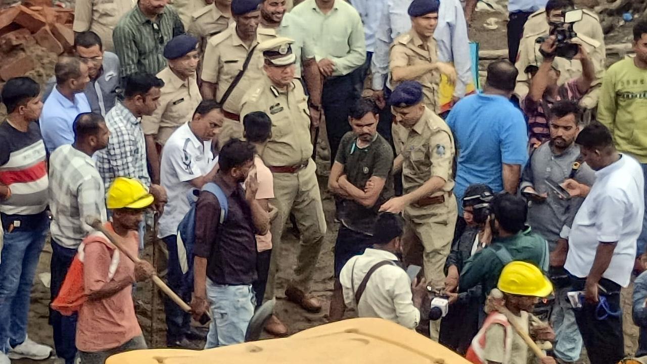 Officials during a rescue operation after a building collapse in Surat. Pics/PTI