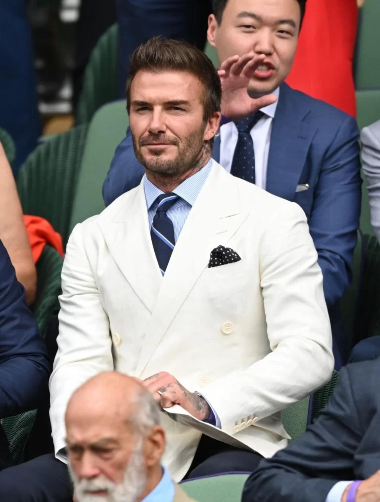 Football legend David Beckham looked sharp in this white suit, light blue shirt and striped tie for the event