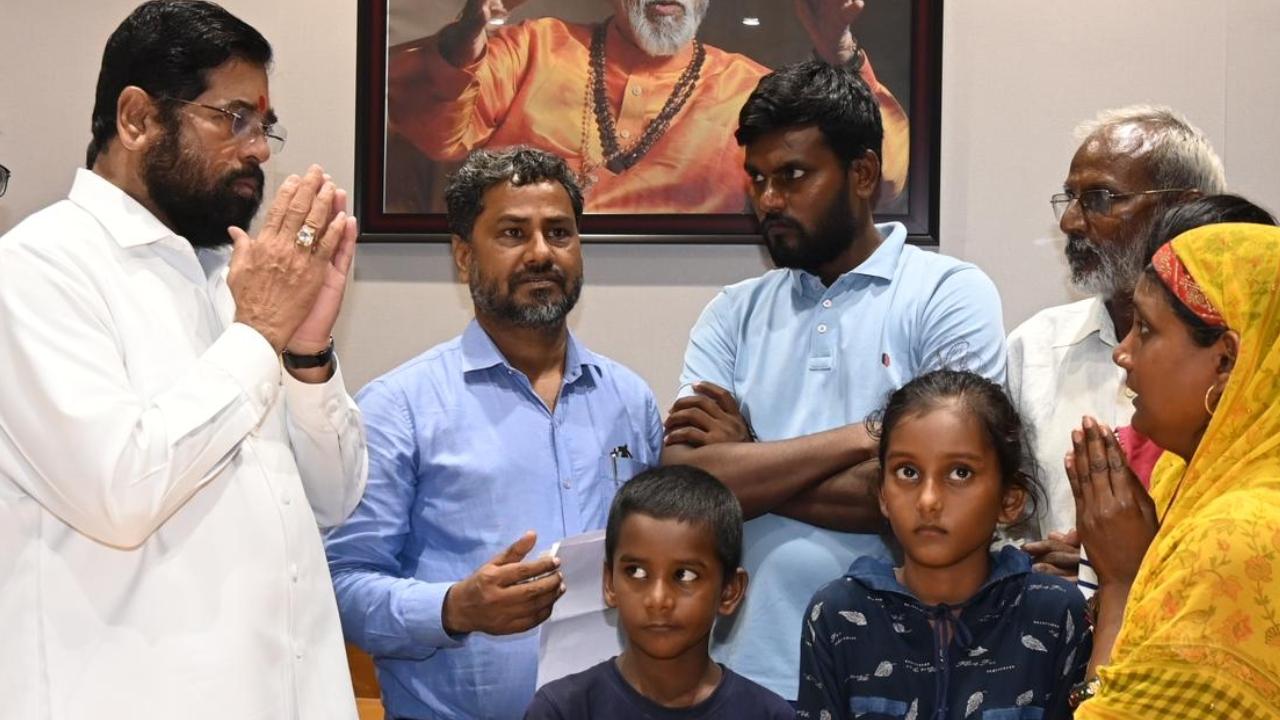 CM Eknath Shinde handed over the cheque of Rs 50 lakh to the deceased labourer's wife Sushila, his father Balchandra Yadav, children Rishu and Pari and others at the CM's residence