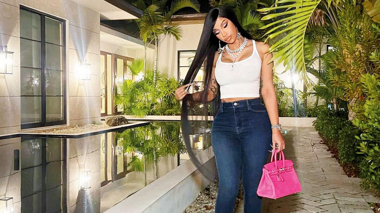 Cardi B demonstrated how she sprays her cleansed hair with rice water, on social media
