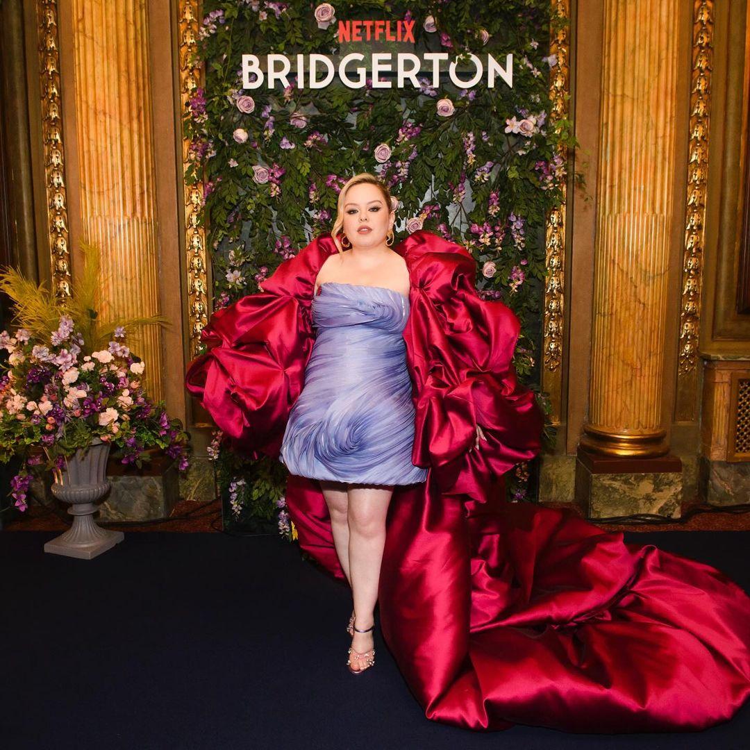 On another red carpet, Coughlan wore a romantic outfit from Sara Mrad’s spring 2024 couture collection. She coordinated with the backdrop of flowers, wearing a lavender strapless dress with a crimson cape resembling petals. Her mini dress had detailed ruching all over!