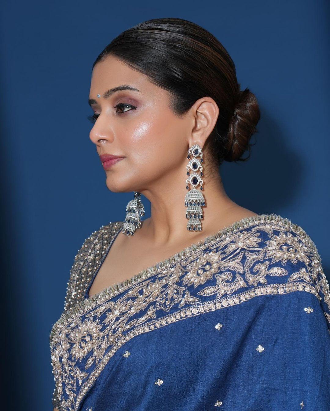 The actress tied her hair in a chic bun and applied smokey eyeshadow and glossy makeup. She wore intricate and long earrings to enhance her look