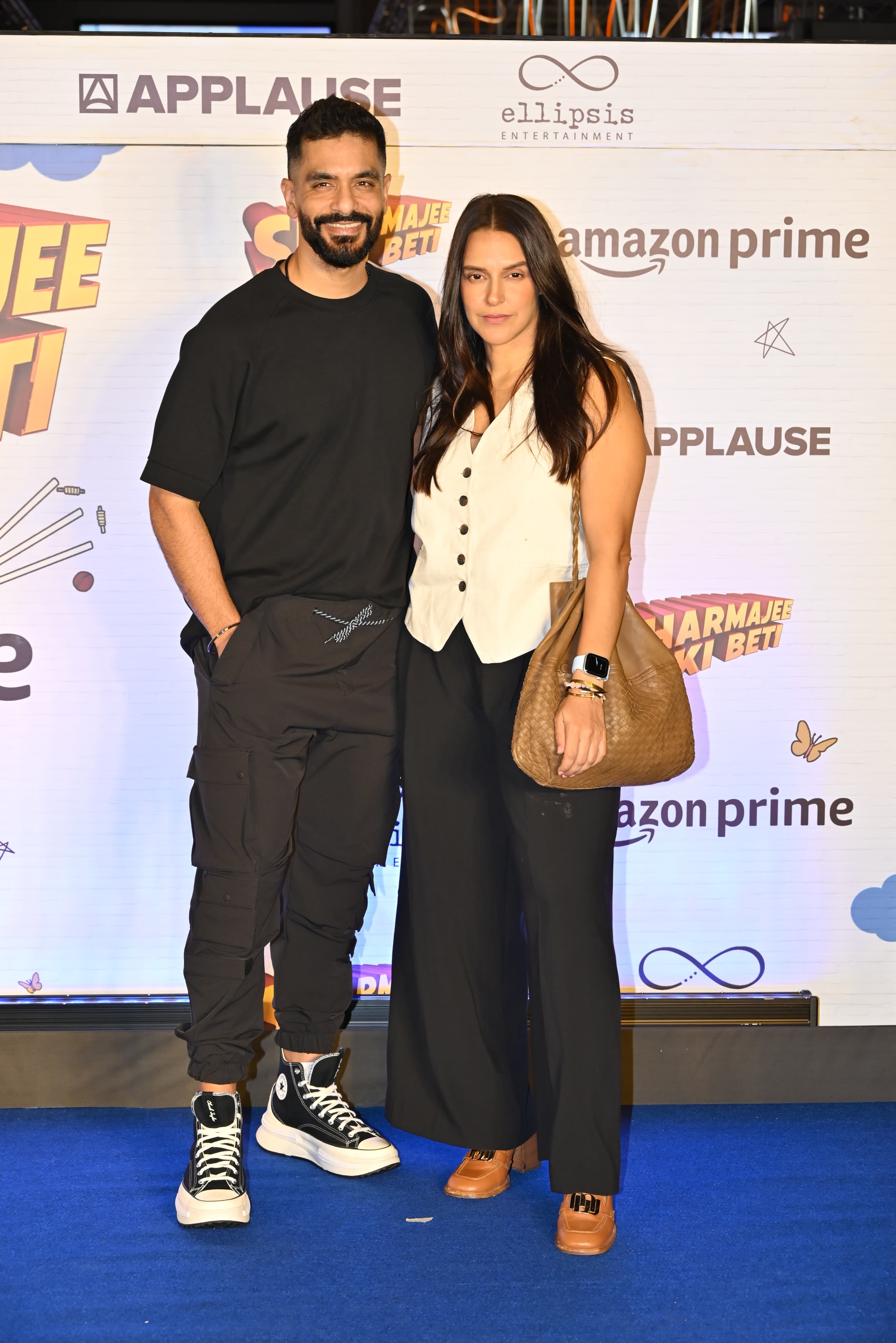 Angad looked stylish in all black while posing with his wife, who wore a white vest top and black flowy pants