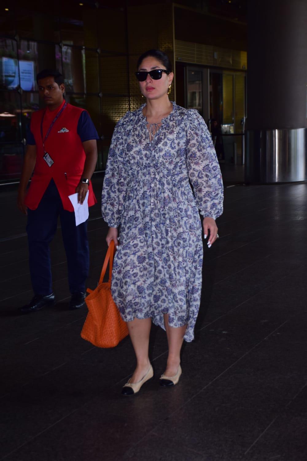 Kareena Kapoor chose a printed gown for her airport look. The actress chose an orange purse to complete her look