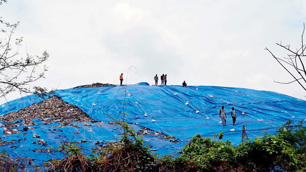 Workers atop the mountain of garbage at CIDCO’s landfill in Ghotawade. Residents claim that the black sludge from the decaying garbage heaps at has been poisoning their crops and livestock by seeping into the soil and groundwater, especially during the monsoon