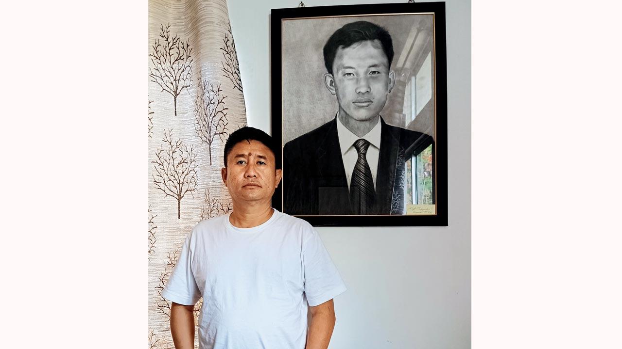 Neingutoulie Kengurüse in his Dimapur office under a portrait of Capt Neibu