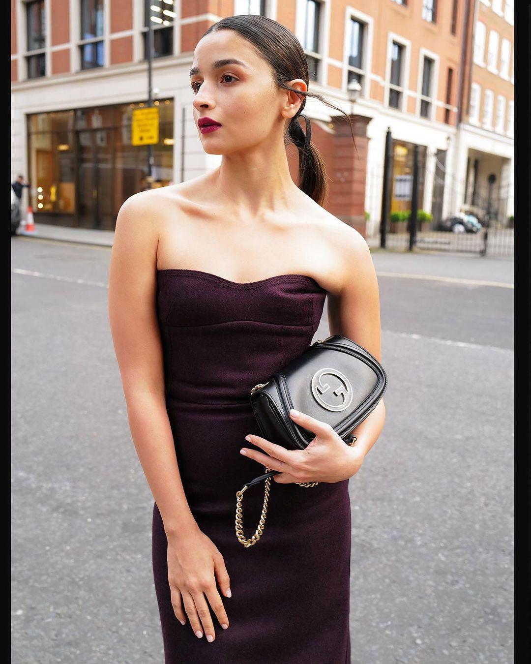 Alia's black Gucci dress had a strapless plunging neckline, a cinched detail under the bust and waist, a corseted bodice, and a midi length hem that hugged her figure.