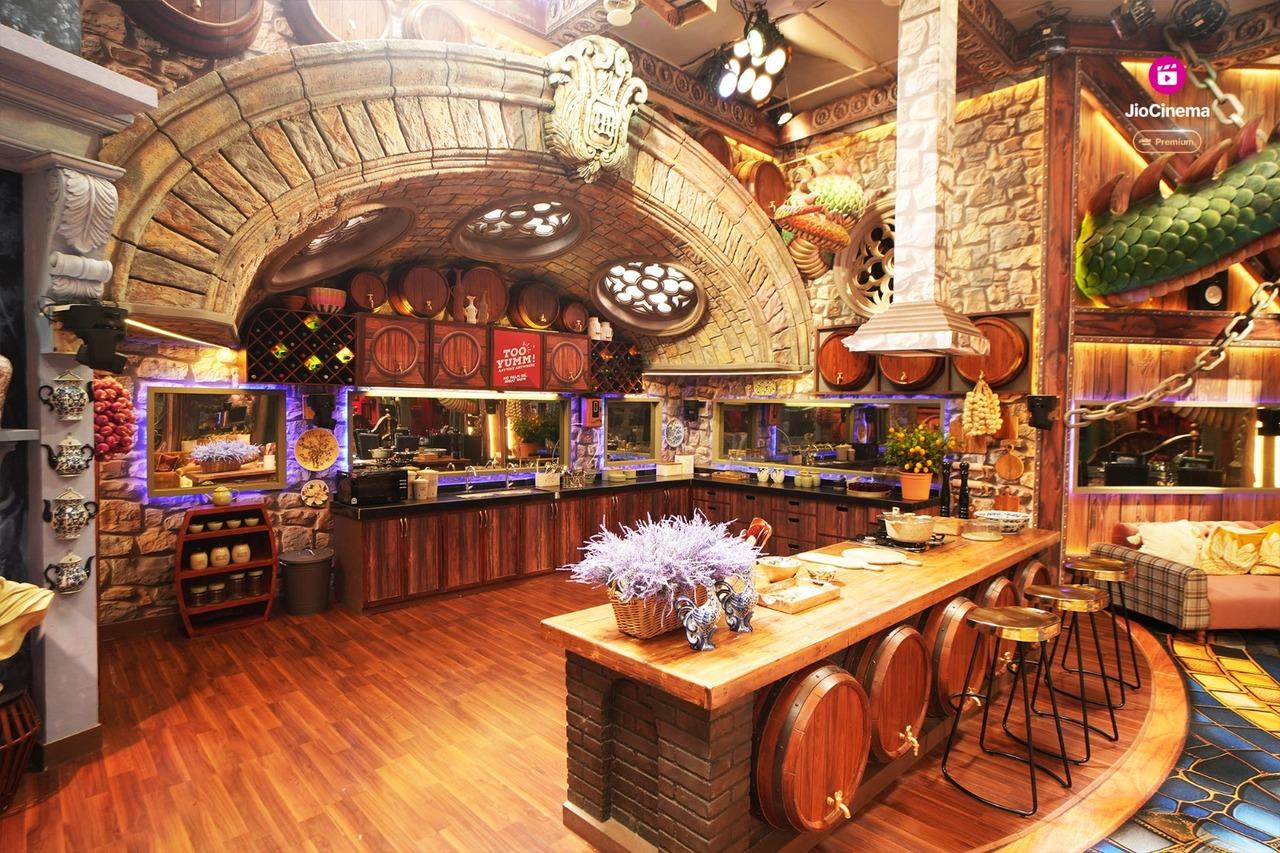 The distinct features of the house continue with a kitchen that resembles a quaint vineyard, complete with stone walls and whimsical wine barrels, creating a cozy yet playful vibe. A large bridge connects the living room and storeroom, suspended over a water-printed carpet, adding a serene touch to the house.  