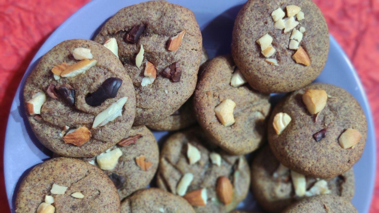Ragi CookiesIngredients:Ragi flour - 100 gmWheat flour- 30 gmBesan flour - 10 gmOrganic jaggery - 30 gm Organic cocoa/choco-chips -1tbsp Virgin Coconut Oil/melted butter/ghee - 20 gm Milk - 50 ml Chopped nuts (cashews, almonds) - 20 gm Organic Choco Chips - 5 gm Baking powder - 1/4 tsp or a pinch  Method:In a bowl, blend ghee or butter with jaggery powder with a whisk or blender until it froths and is creamy and fluffy or until ghee turns whitish. 
Sieve and add ragi flour, wheat flour cocoa powder, baking powder, and chopped nuts add enough milk to make a chapati dough-like consistency. 
Make lemon-sized balls of dough, flatten them, carve a design with a fork or toothpick, and garnish with nuts and choco chips. 
On a greased porcelain or microwave-friendly tray, arrange the raw cookies and bake at 180 degrees Celsius for 10 minutes. You can also bake in a smaller cake tin/tray fitted into a wide pre-heated tawa or cooker for 10 minutes or until cookies turn light brown and crispy. 
The tawa or cooker needs to have some table salt or dry sand on the floor of the tawa, preheated for 10 minutes before baking. Cool completely and serve and enjoy. 
Recipe by Shilpa Kumar, in-house organic recipe curator, Akshayakalpa Organic 