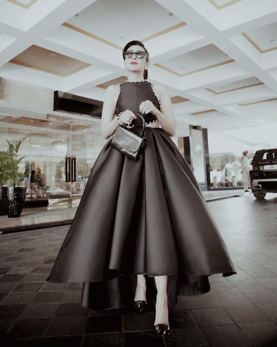 The dress, made from luxurious Mikado fabric, featured a sleeveless design adorned with delicate pearl embellishments around the round neckline.