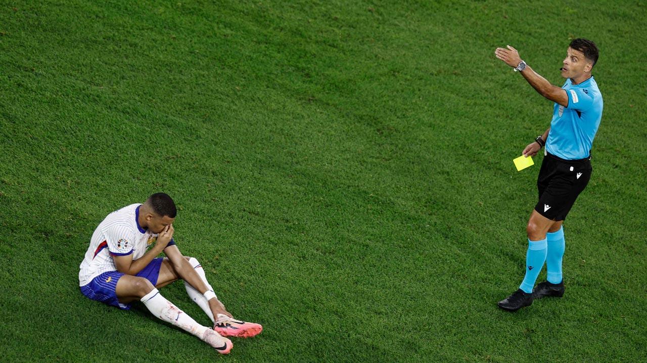Spanish referee Jesus Gil Manzano prepares to present France`s forward Kylian Mbappe with a yellow card during the UEFA Euro 2024 Group D football match between Austria and France at the Duesseldorf Arena in Duesseldorf. Pic/AFP