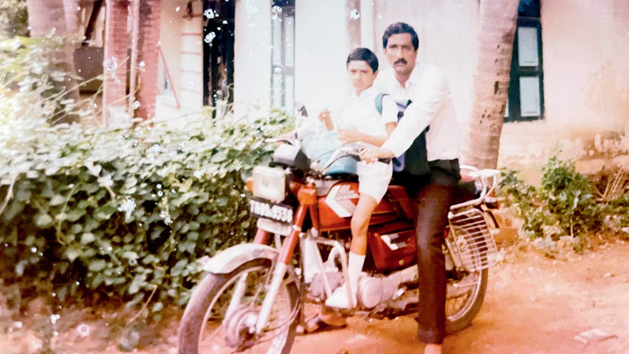 “Appa, not yet confident of letting me sit behind him on the bike. This way his arms protect me from falling”