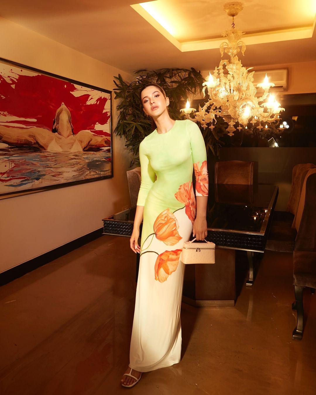 The pattern is eye-catching with green, white, and peach flowers all over. It fits her like a glove and shows off her figure perfectly.
