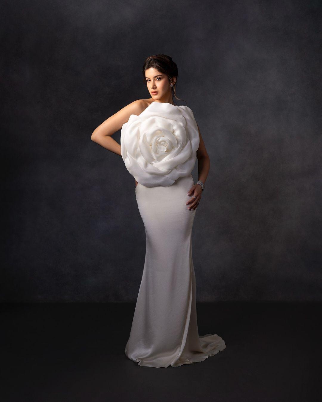 The white gown hugged her curves perfectly and had a giant, three-dimensional rose right in the middle, covering the front of her dress.