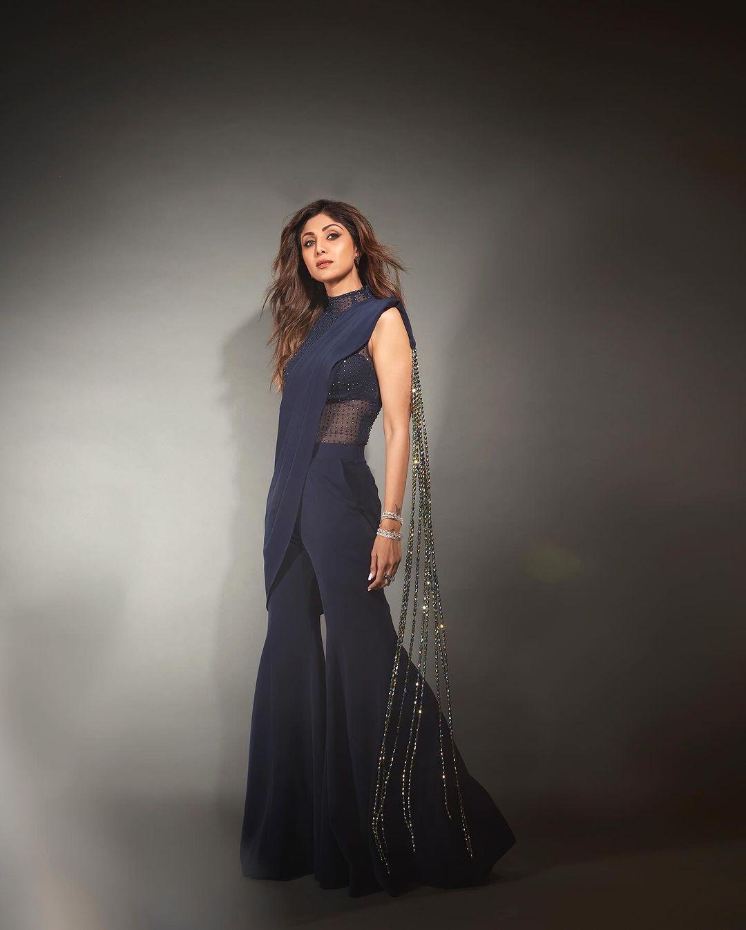 Her midnight blue pant saree had a stylish blouse with a high collar and a sleeveless design, complete with bustier details and a see-through look that added an extra oomph.