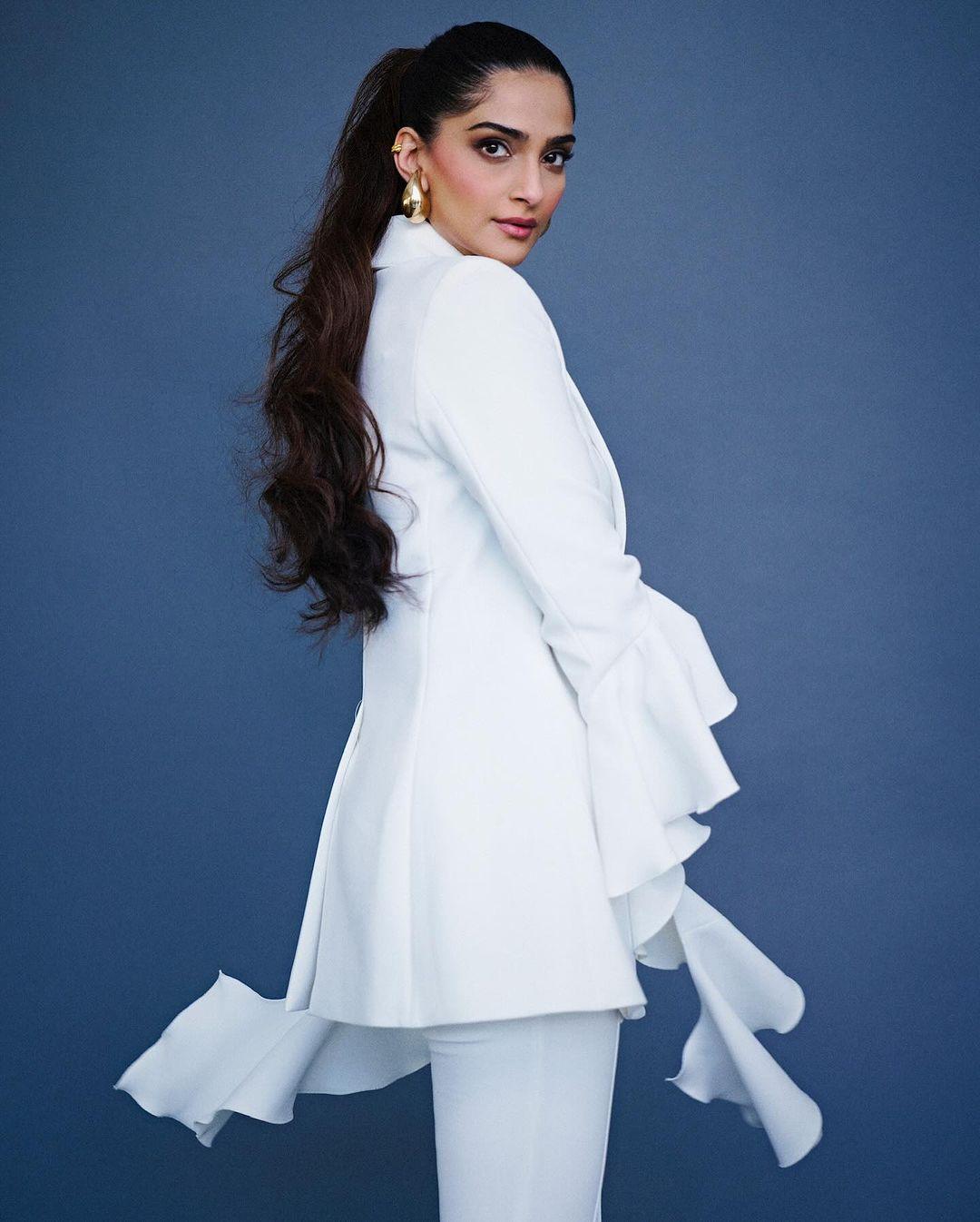 This elegant and luxurious pantsuit, crafted in France, featured a stylish white blazer with crisp lapels and a B-shaped neckline with unique long ruffled sleeves that stood out. 