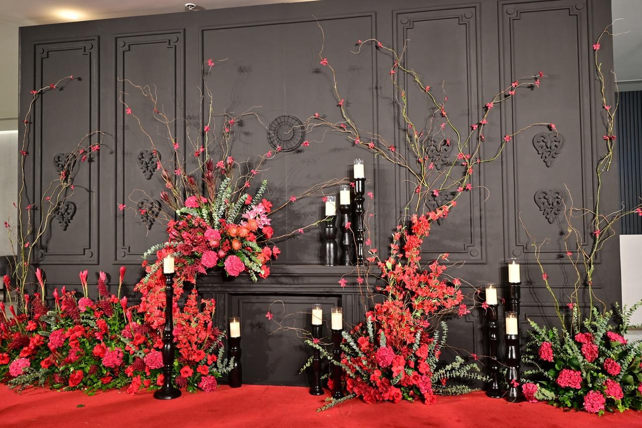 For Sunday night's party, the theme is black and red, and a team of decorators at work in Bastian arranged an array of red flowers and rolled out the red carpet.