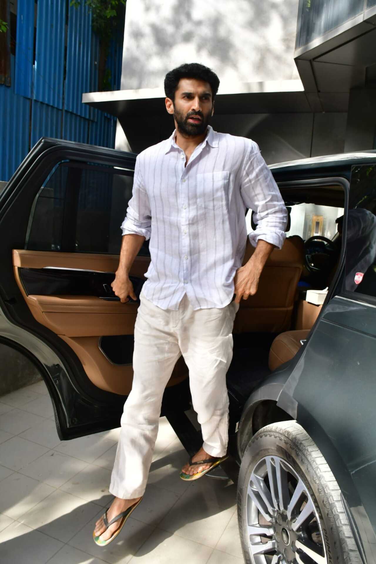 Actor Aditya Roy Kapur exuded summer vibes in a white striped shirt and ivory chinos. 