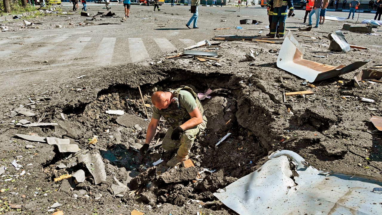 A bomb technician at the site of a destroyed building in Kharkiv