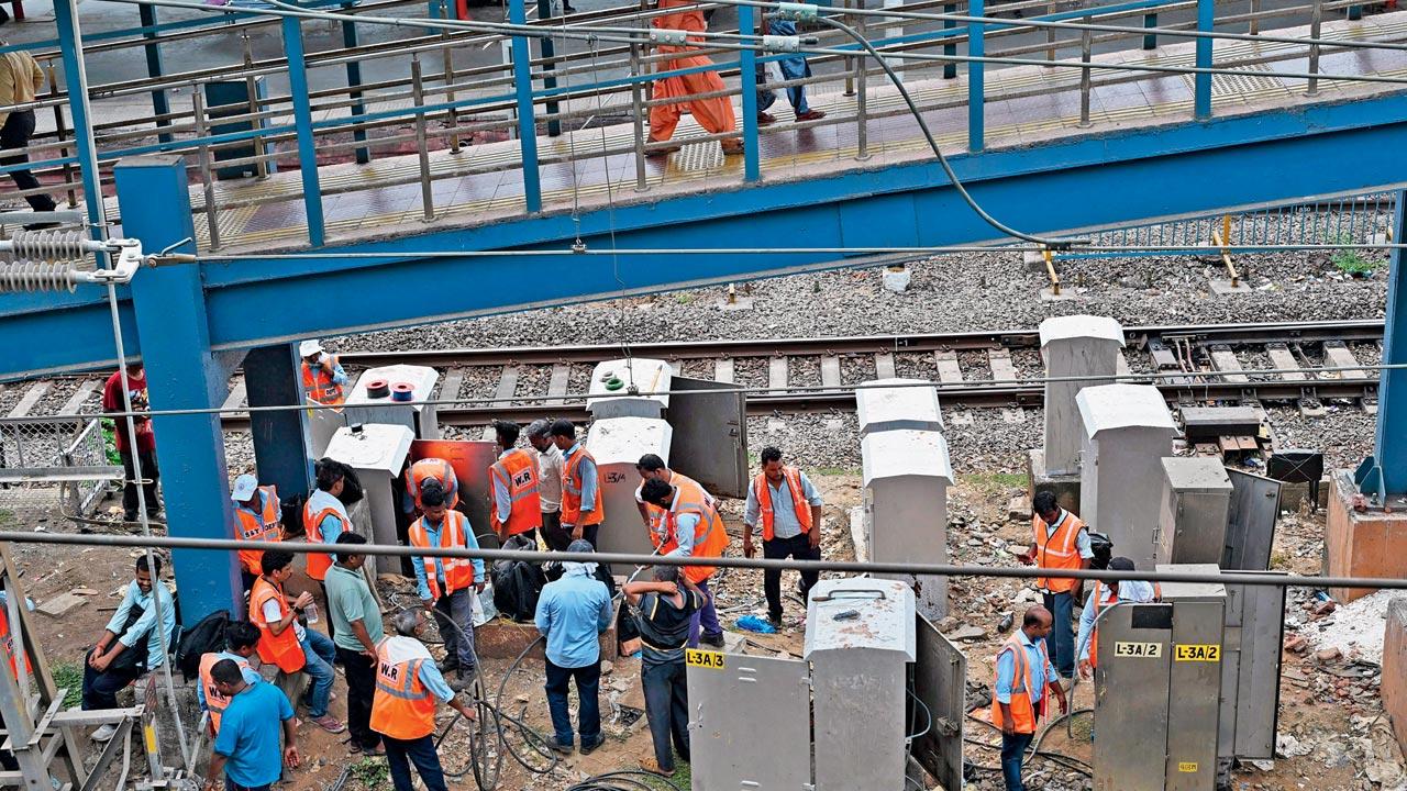 Railway officials along with the linemen were working on technical errors at Borivli station on Monday. Pics/Satej Shinde