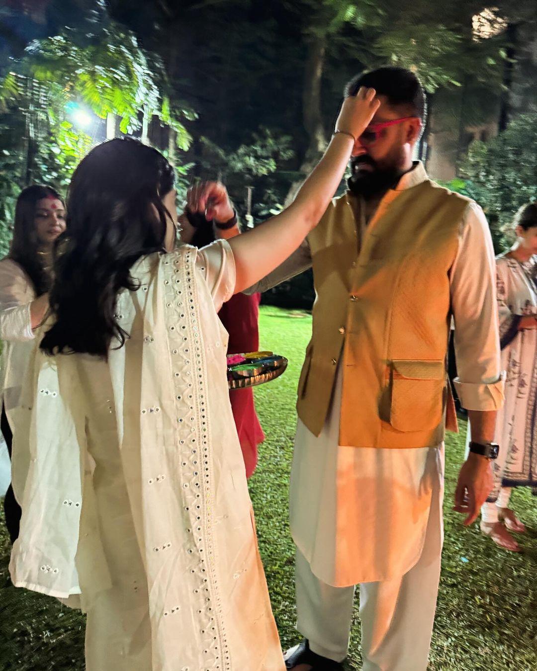 In yet another photograph from last night's Holika Dahan celebration, Navya was seen putting colour on her mamu Abhishek. In this pic, we could also spot Aishwarya Rai in the background