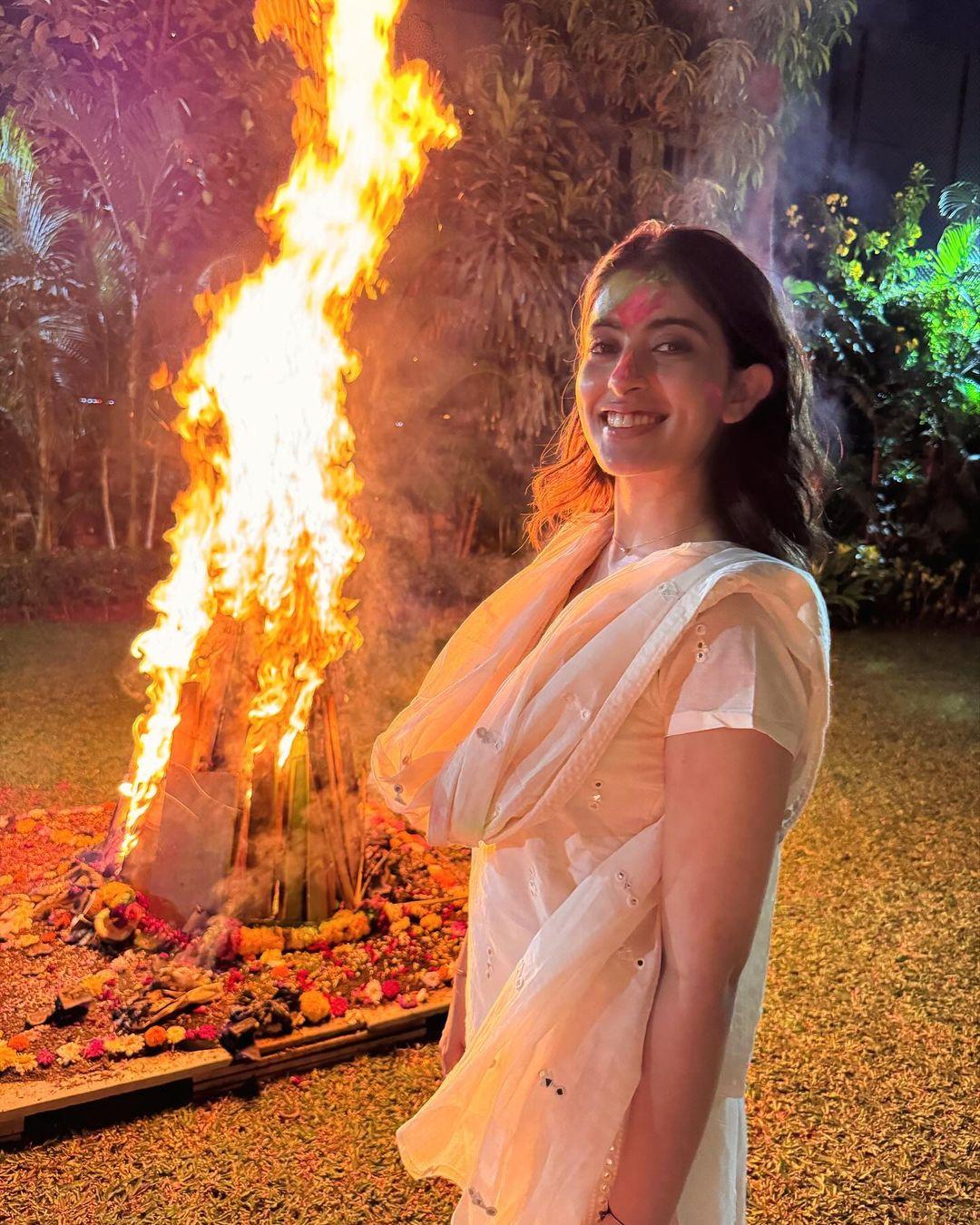 In this picture, Navya struck a pose in front of the burning Holika