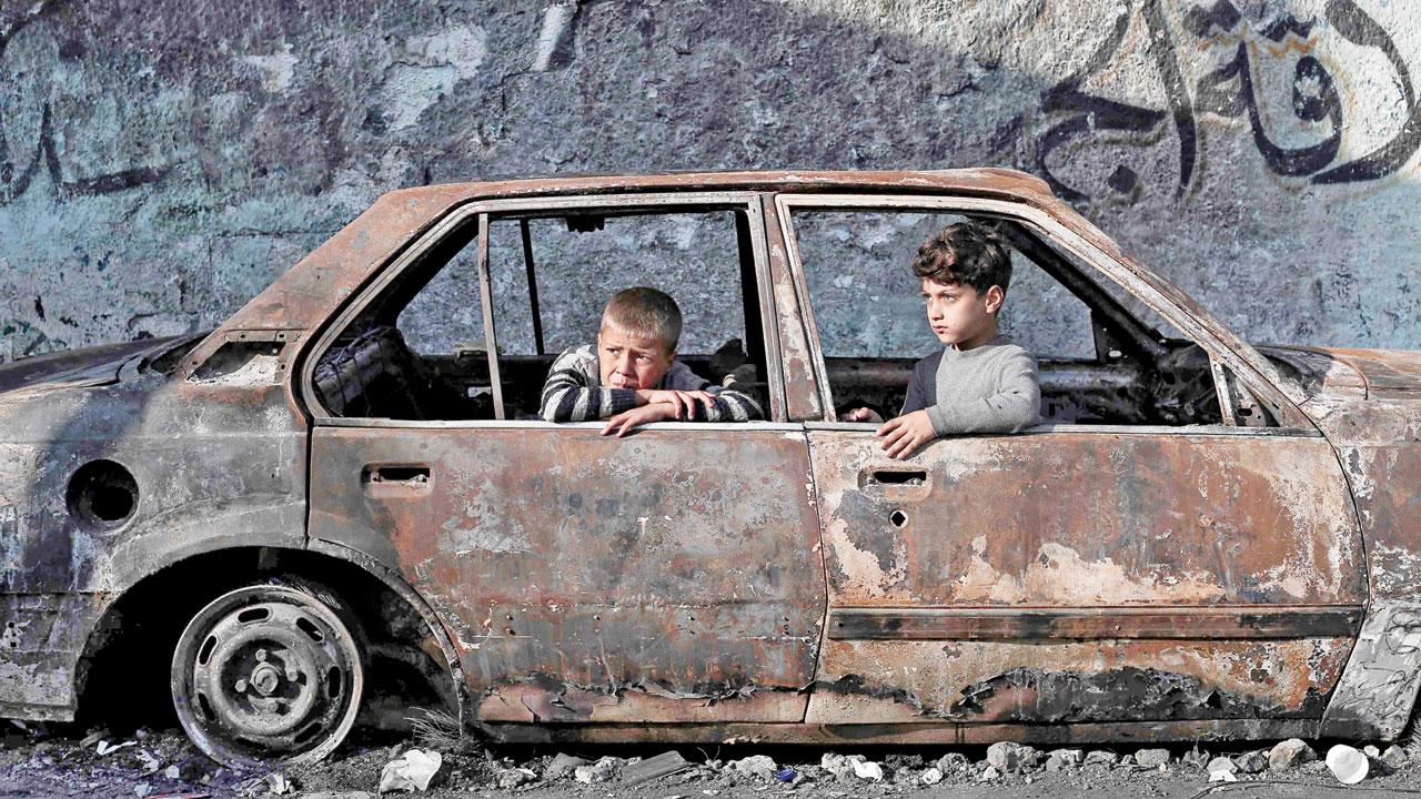 Children play in a destroyed car in Rafah. Pic/AP