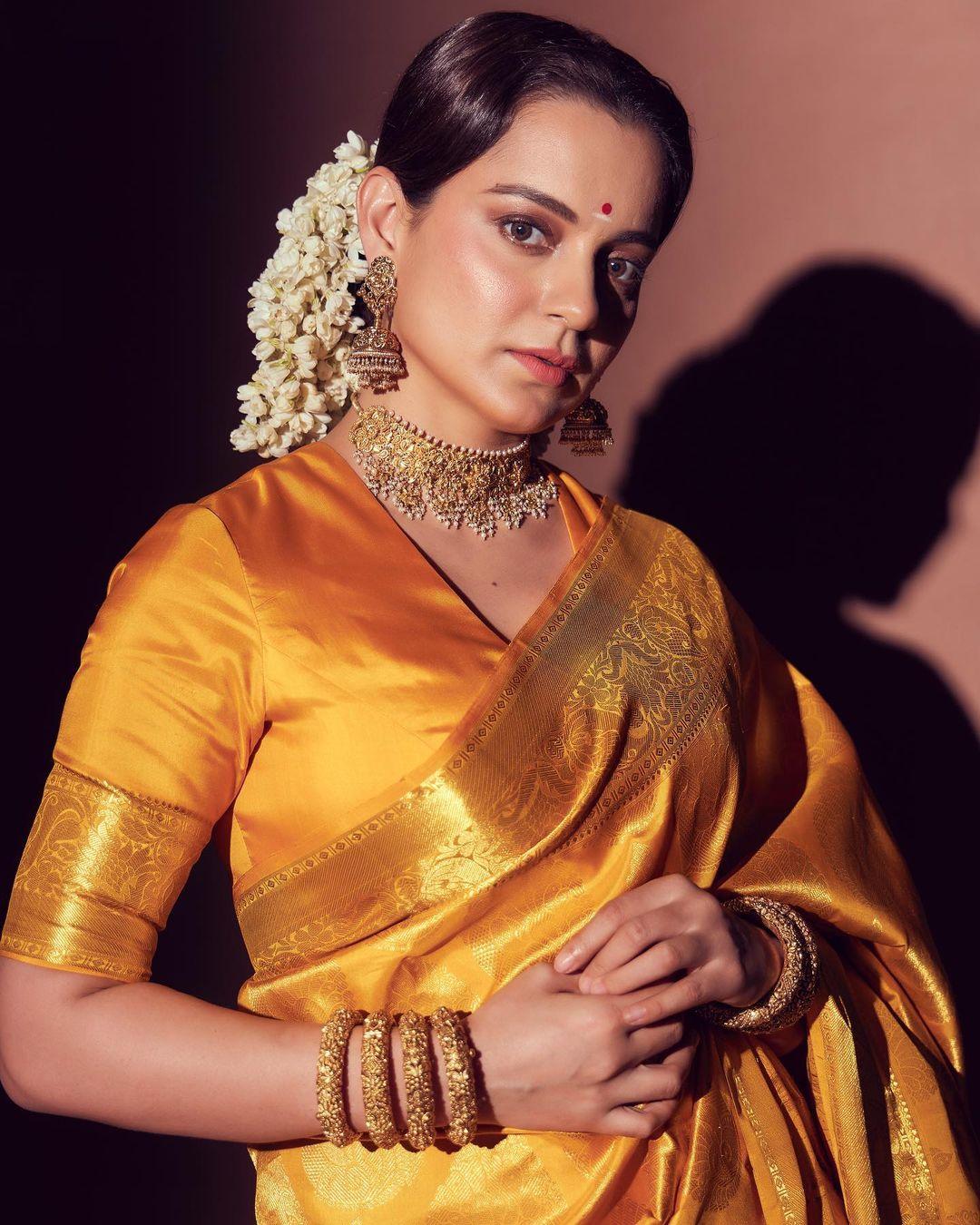 In this look, Kangana wore a stunning golden saree with a matching yet intricate border. Kangana paired her saree with a matching blouse. With her hair tied in a bun, the actress elevated her hairstyle with a beautiful gajra