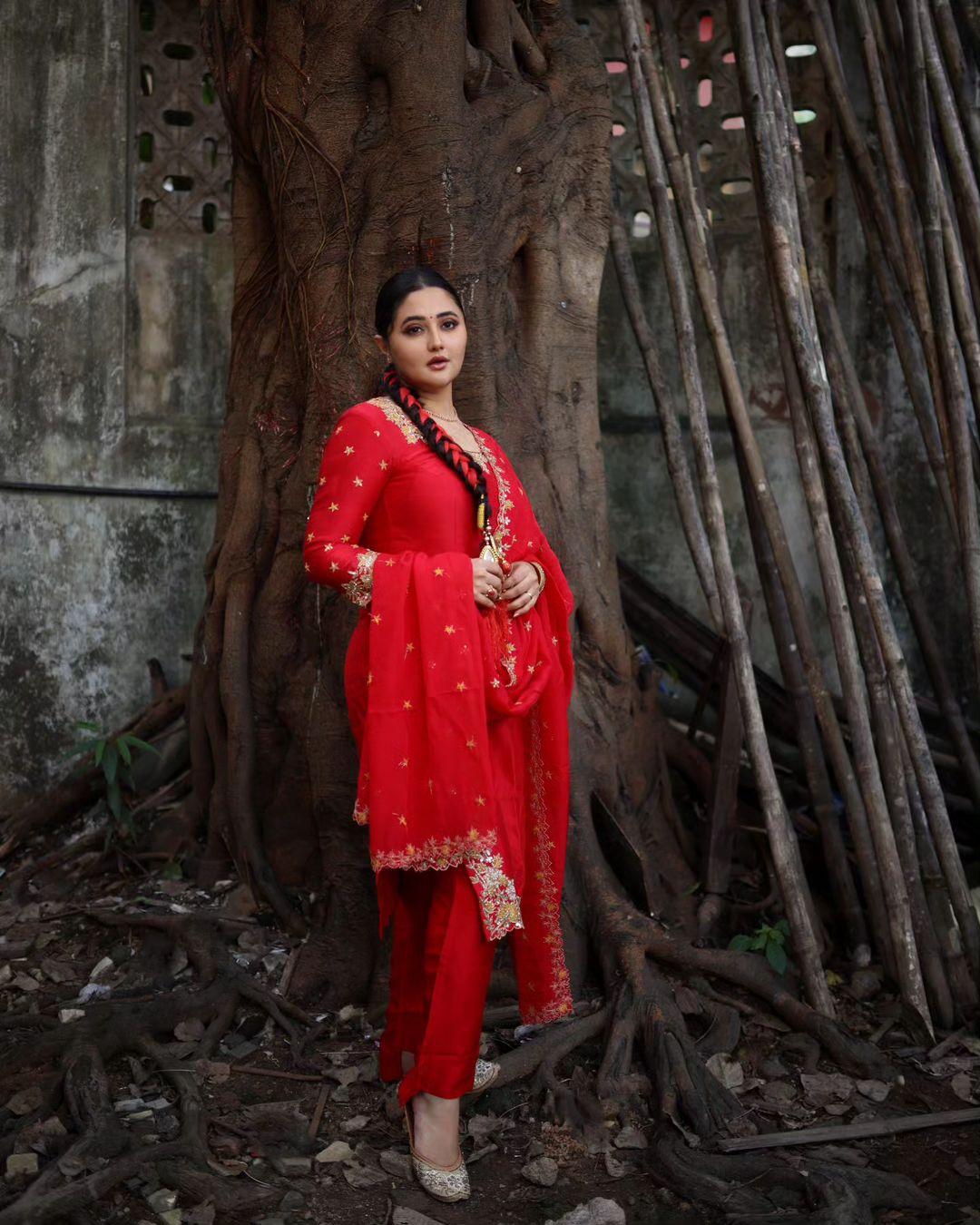 In this traditional appearance, Rashami Desai captivates in a red kurta paired with matching pants and a dupatta. The beautiful intricate designs on the suit add a touch of sophistication. Tying her hair in braids imparts a unique and charming aspect to the overall look