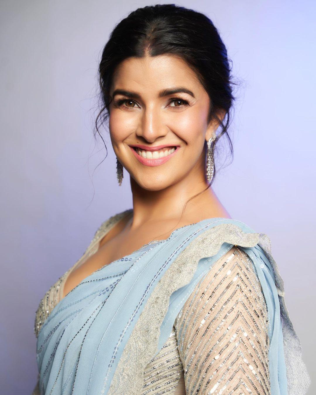 The actress's saree has a matching border, making it a perfect fit for days when you want a simple yet classy look. Nimrat tied her hair in a loose ponytail and opted for simple nude makeup to finish her look