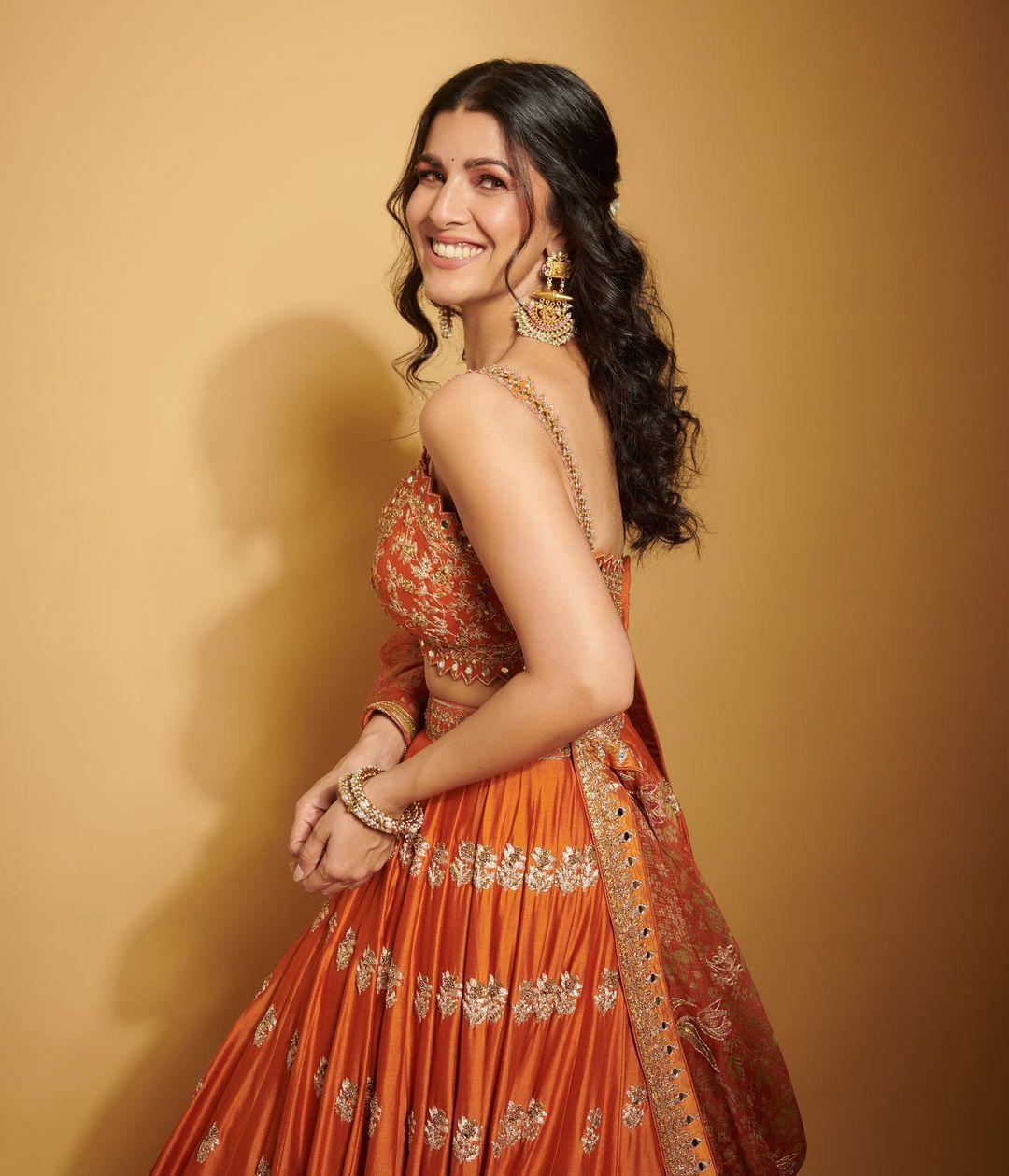 Nimrat wore a stunning orange lehenga with golden embroidery and paired it with a matching blouse